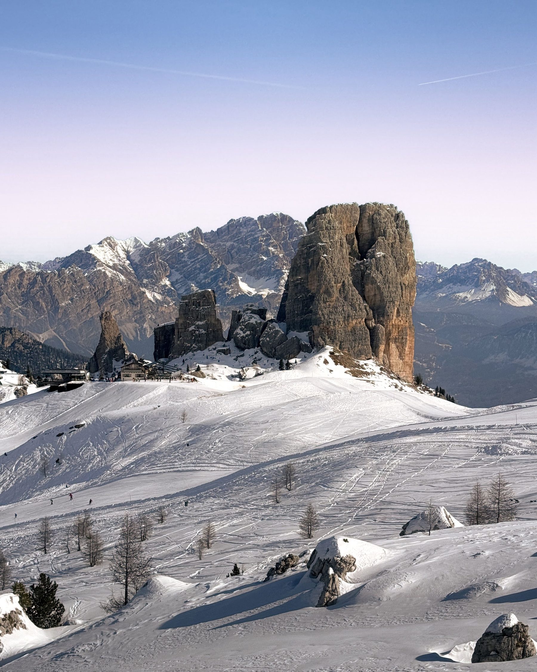 The Cinque Torri rock towers above snowy slopes near Cortina