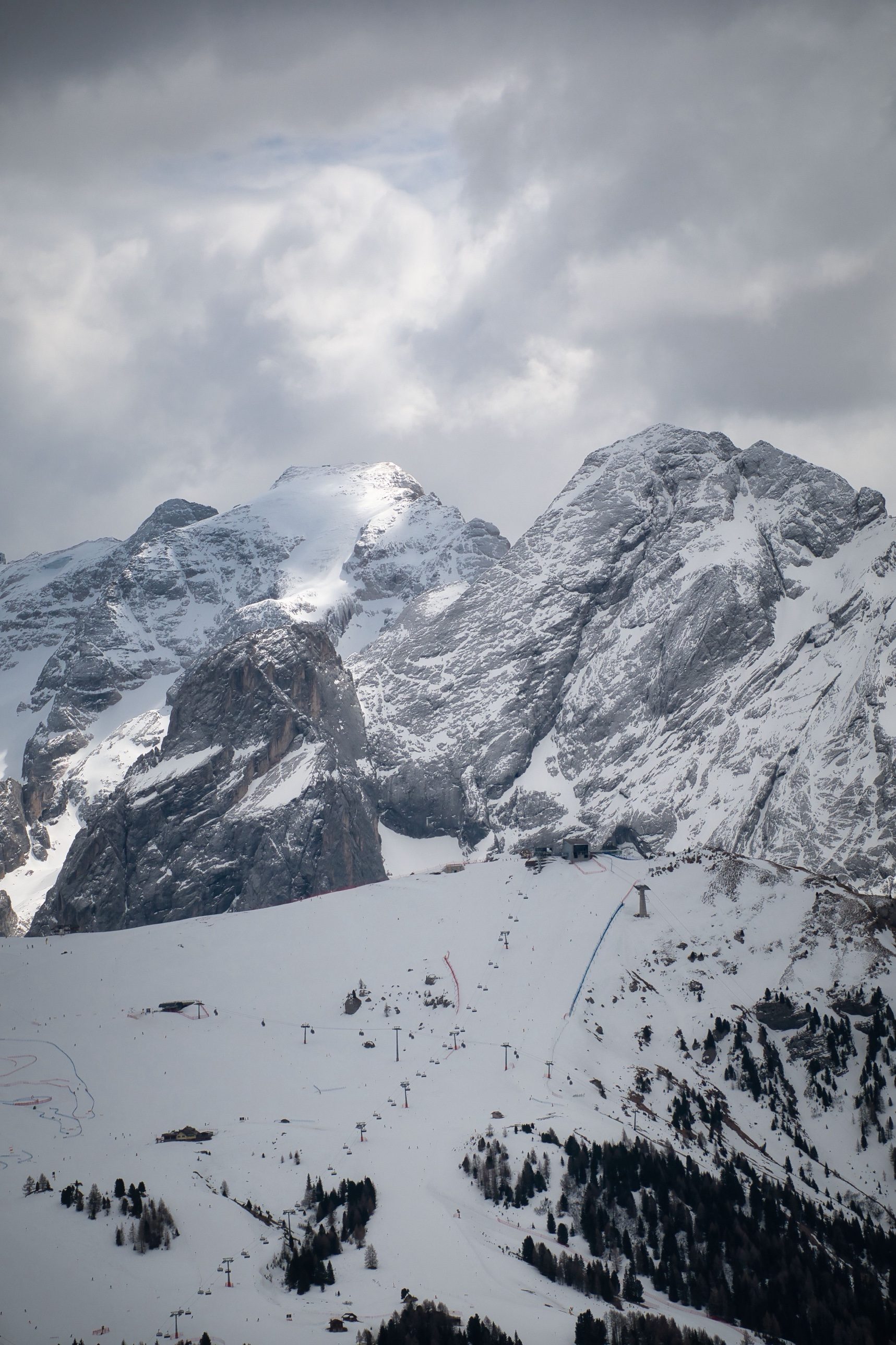 Chairlifts and pistes below the snowy Marmolada
