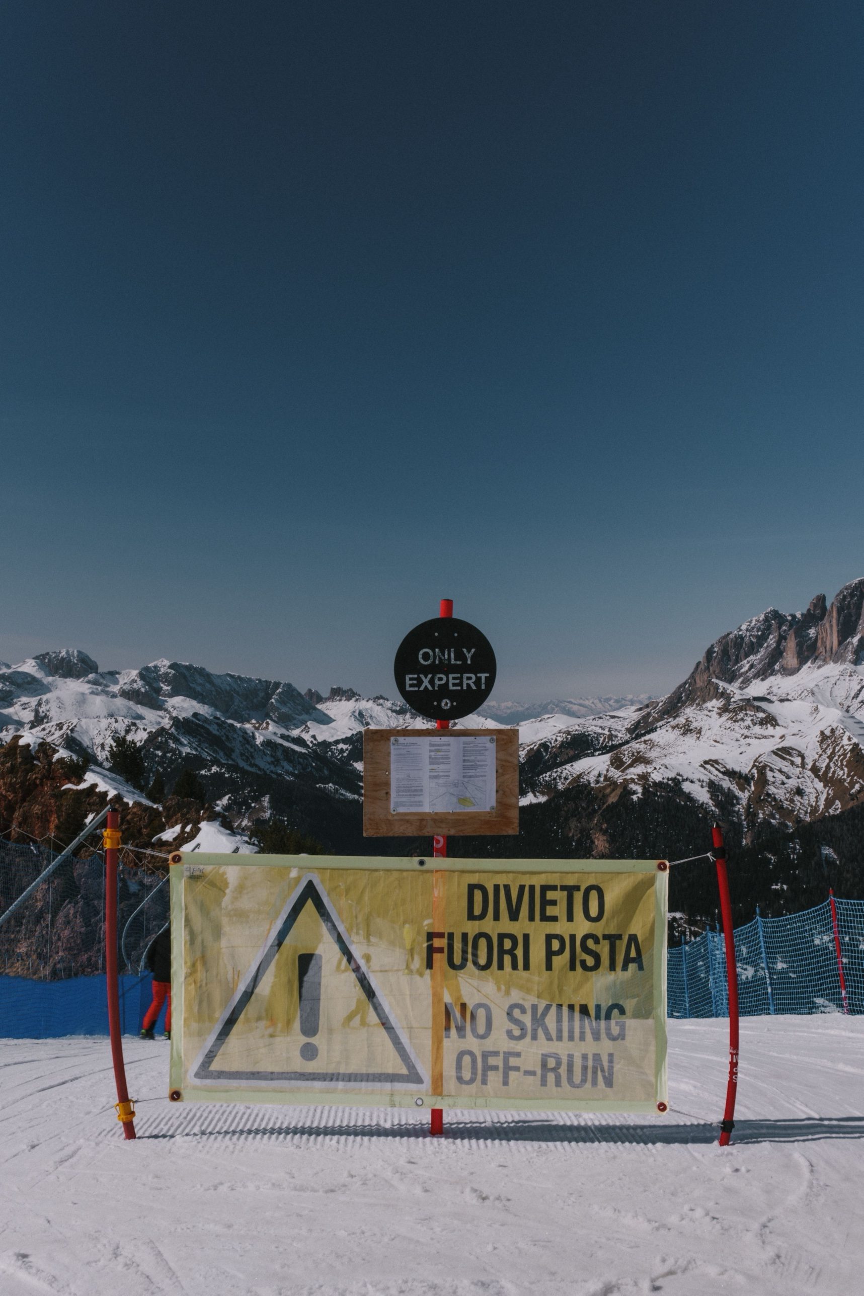 A sign on a piste reading Divieto fuori pista, No skiing off-run