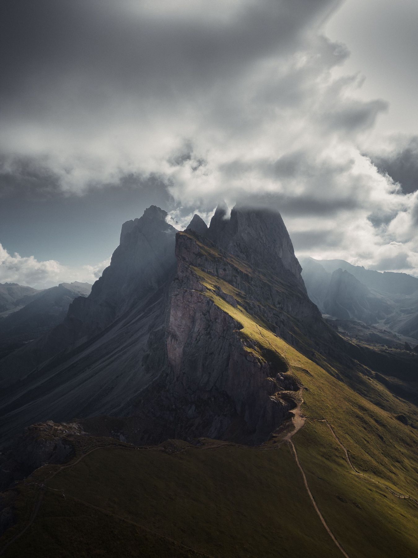 The Seceda ridge under heavy cloud with a shaft of light on the grass
