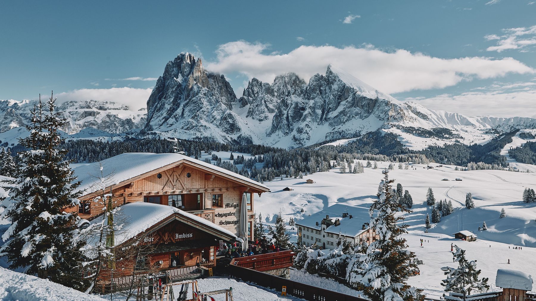 A snowy ski hut with jagged peaks behind