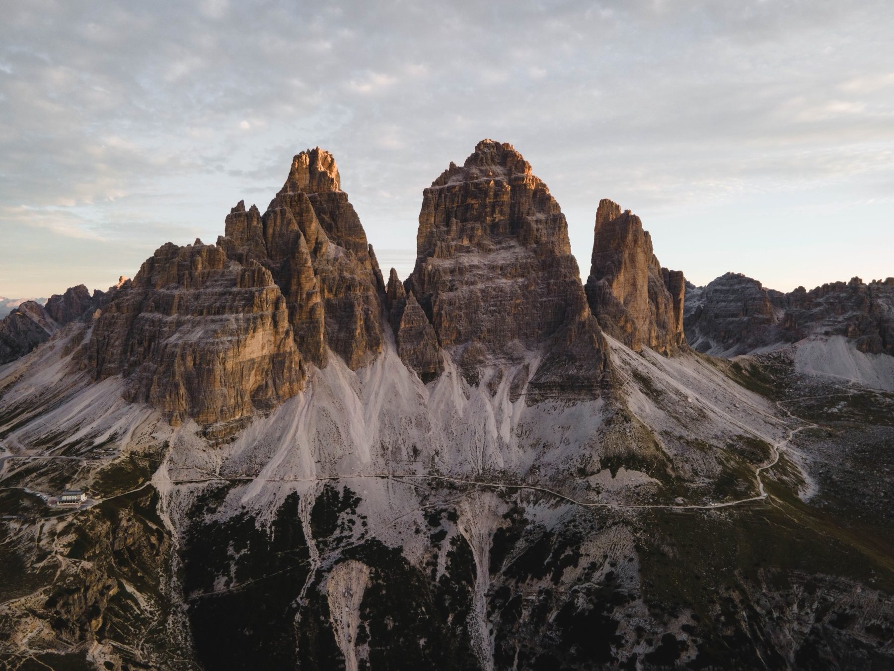 Aerial view of Tre Cime di Lavaredo at first light with Rifugio Auronzo below